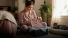 Cat lover opening a personalized pajama gift while their cat rests naturally nearby