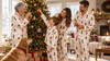 Family decorating the tree in matching personalized Christmas pajamas