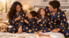 Family wearing personalized photo pajama sets in a warm bedroom