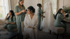 Bride and bridal party getting hair and makeup done naturally while wearing coordinated button-up pajamas