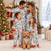Family of four and their dog in matching aqua cocoa mug and cookie Christmas pajamas and bandana in a decorated living room