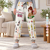 Woman wearing personalized wine sweatpants with the quote Just A Woman Who Loves Wine and a cartoon woman holding a wine bottle with her name, in a cozy living room