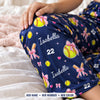 Close-up of the white script name and jersey number print among softballs, pink bows and sparkles
